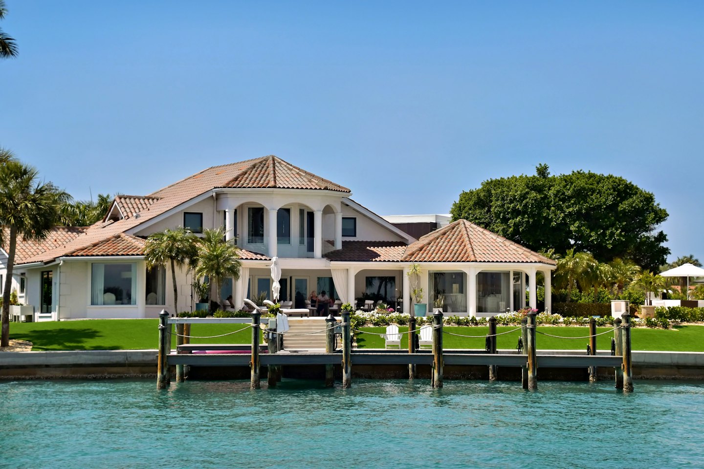 Luxury waterfront residence with a private dock on turquoise water.
