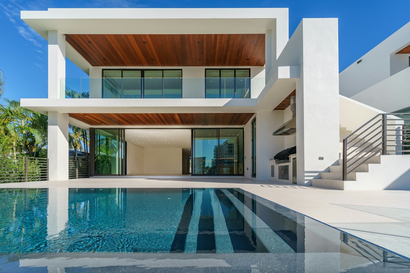 Luxury modern home with swimming pool and palm trees.